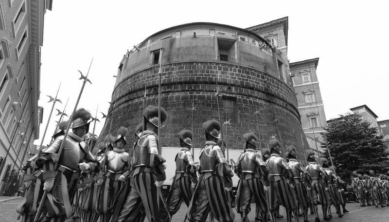 Swiss guards pass by the Vatican Bank (IOR), located in the Niccolo V tower in the Vatican (2015).